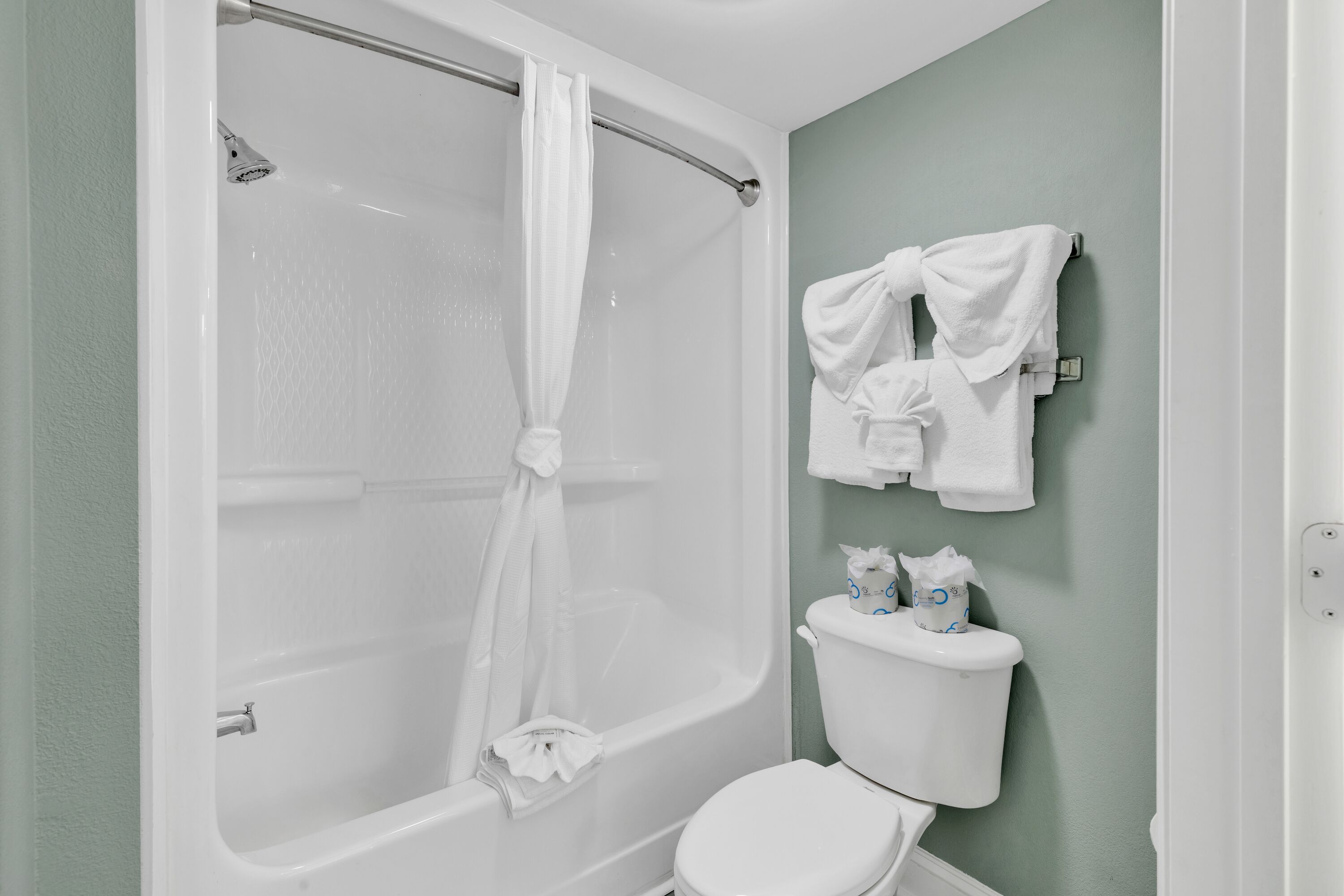 A bathroom with a bathtub, toilet, and towel rack.