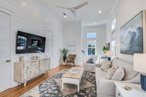 A spacious living room with a flat-screen TV, a wooden cabinet, a coffee table, a sofa, and a large painting. - BVR 05 - Blue Heaven by Liquid Life (Orange Beach)