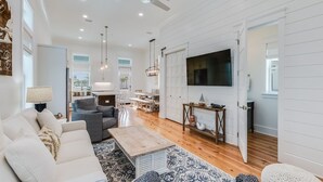 A spacious living room with a sofa, coffee table, and TV. - BVR 40 - Isle Be Back by Liquid Life (Orange Beach)