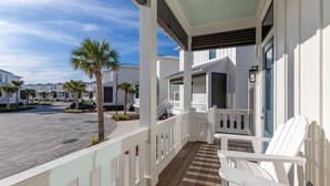 A covered outdoor area with white railings, a wooden deck, and white chairs. - BVR 40 - Isle Be Back by Liquid Life (Orange Beach)