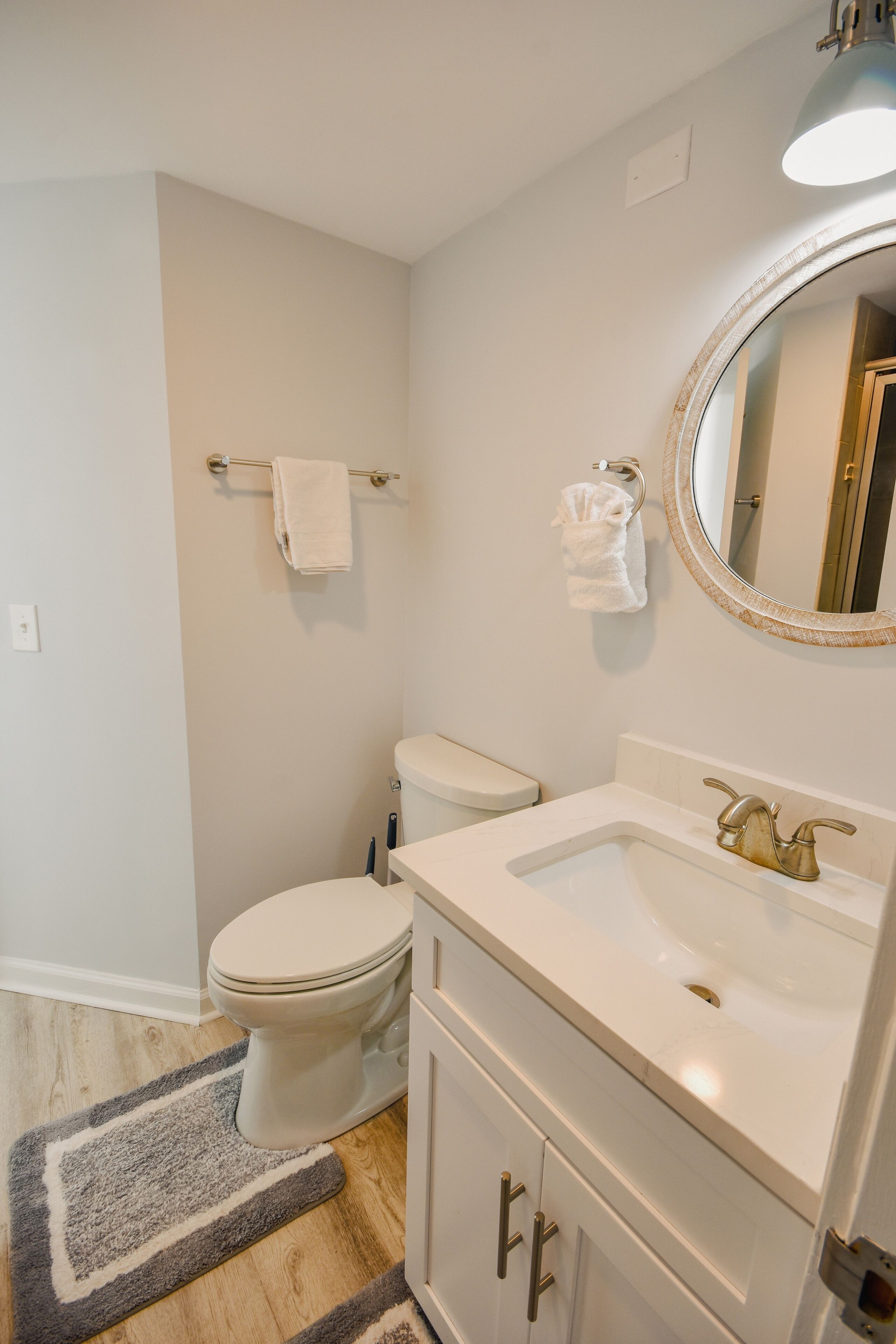 A bathroom with a toilet, sink, and mirror.