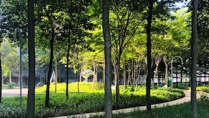 A park with trees, a curved pathway, and a metal sculpture. - Premium Retreat Suite Icon City (Petaling Jaya)
