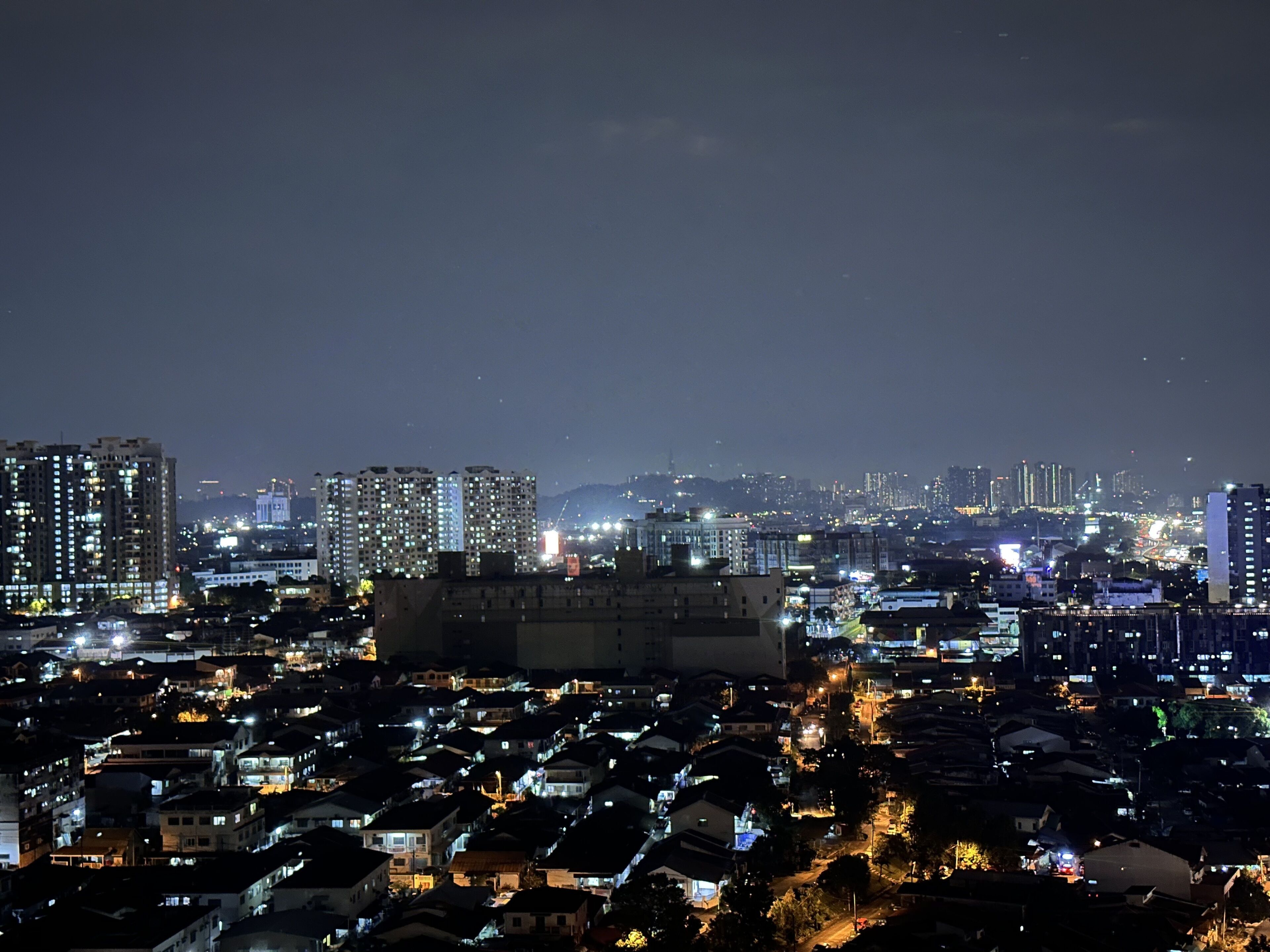 A nighttime cityscape with high-rise buildings and residential areas.