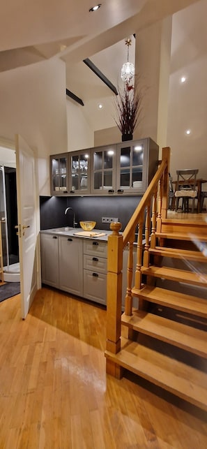 Full-sized fridge, stovetop, electric kettle, cookware/dishes/utensils