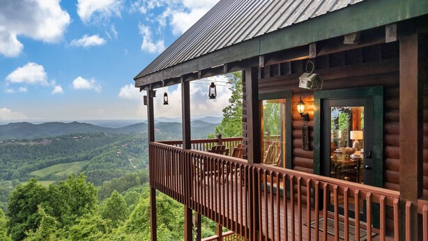 A wooden cabin with a balcony overlooking a mountainous landscape. - Endless VIEWS! 3 decks - cozy - Private-with Game Room, Hot Tub, Arcade (Pigeon Forge)