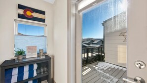 A hotel room with a sliding glass door to a balcony, a sign prohibiting glass or food in the hot tub, and a view of snow-capped mountains. - Private Rooftop Balcony w/ Hot Tub & Panoramic Mountain Views, Close to Shops (Silverthorne)