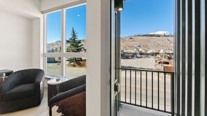 A room with large windows, a balcony, and a view of a snowy landscape. - Private Rooftop Balcony w/ Hot Tub & Panoramic Mountain Views, Close to Shops (Silverthorne)