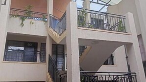 A multi-story building with a glass ceiling, balconies with railings, and staircases.
