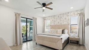 A bedroom with a bed, nightstand, and ceiling fan. - Golf Course Views, Private Pool & Pet-Friendly (Bonita Springs)