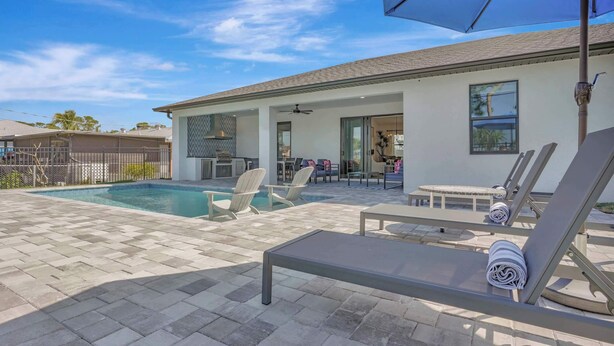 A residential property with a swimming pool, outdoor seating, and a covered patio area. - Golf Course Views, Private Pool & Pet-Friendly (Bonita Springs)