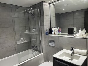 Een haardroger, handdoeken, zeep, toiletpapier