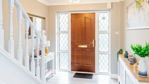 A hallway with a wooden door, white staircase, and a radiator on the wall. - Stunning Place near Windsor & Heathrow, 3BR House (Burnham)