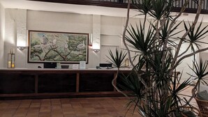 A reception area with a large framed painting of birds on a tree, a reception desk, and a potted plant. - Marina Fish- Boat and Relax in this Paradise newly remodeled in Naples, Florida! (Naples)