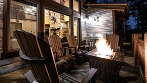 Eine Holzterrasse mit Sitzgelegenheiten im Freien und einem Feuerkorb.
