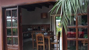An open wooden door leading to a kitchen with a dining table and chairs. - Casa Bugambilia

 (Bejuco)