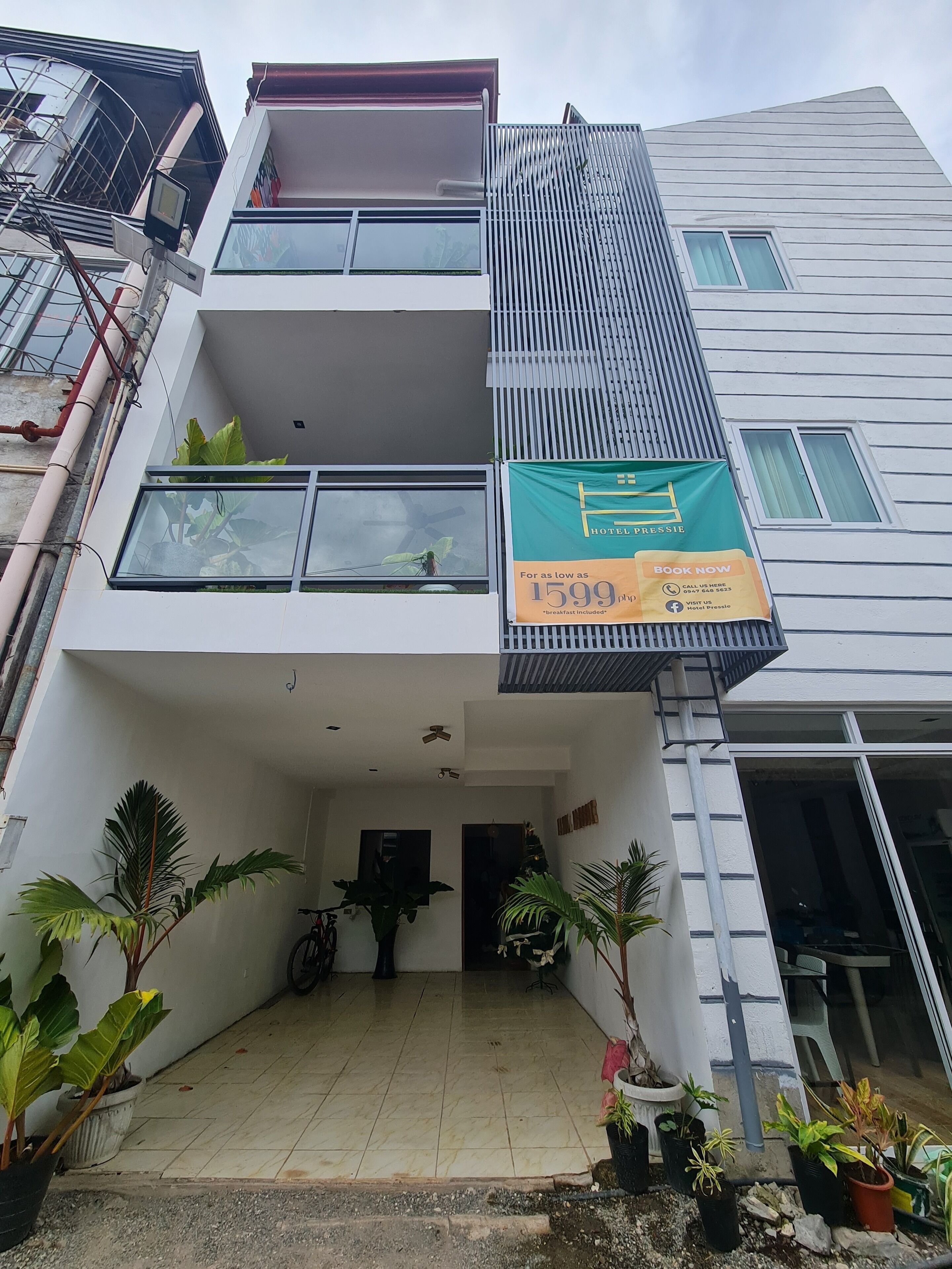 A modern hotel with a flat roof, large windows, and a sign advertising a price of 1599.