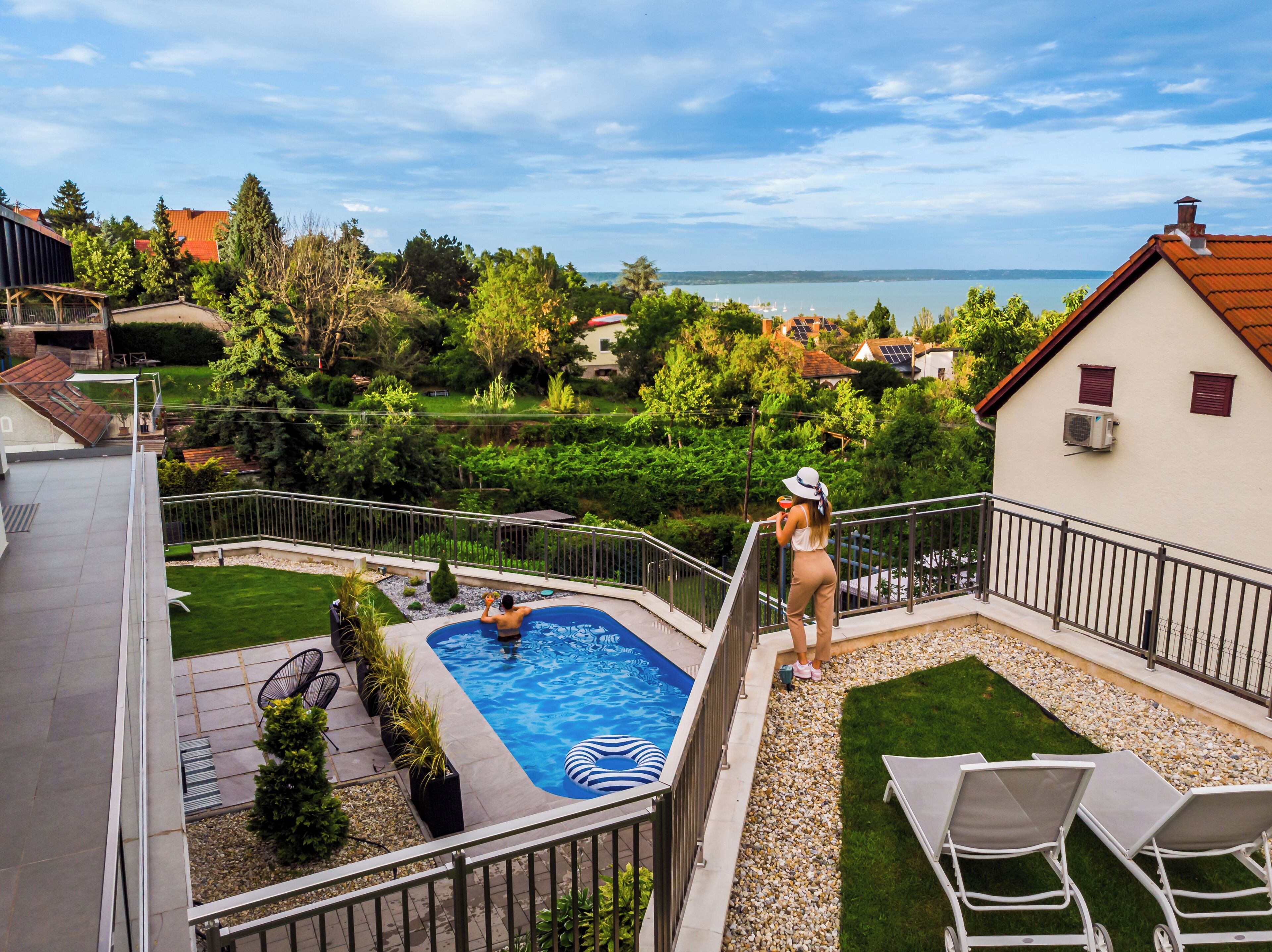 Ein Wohngebiet mit Schwimmbad, einem Balkon mit Meerblick und einem gepflegten Garten.