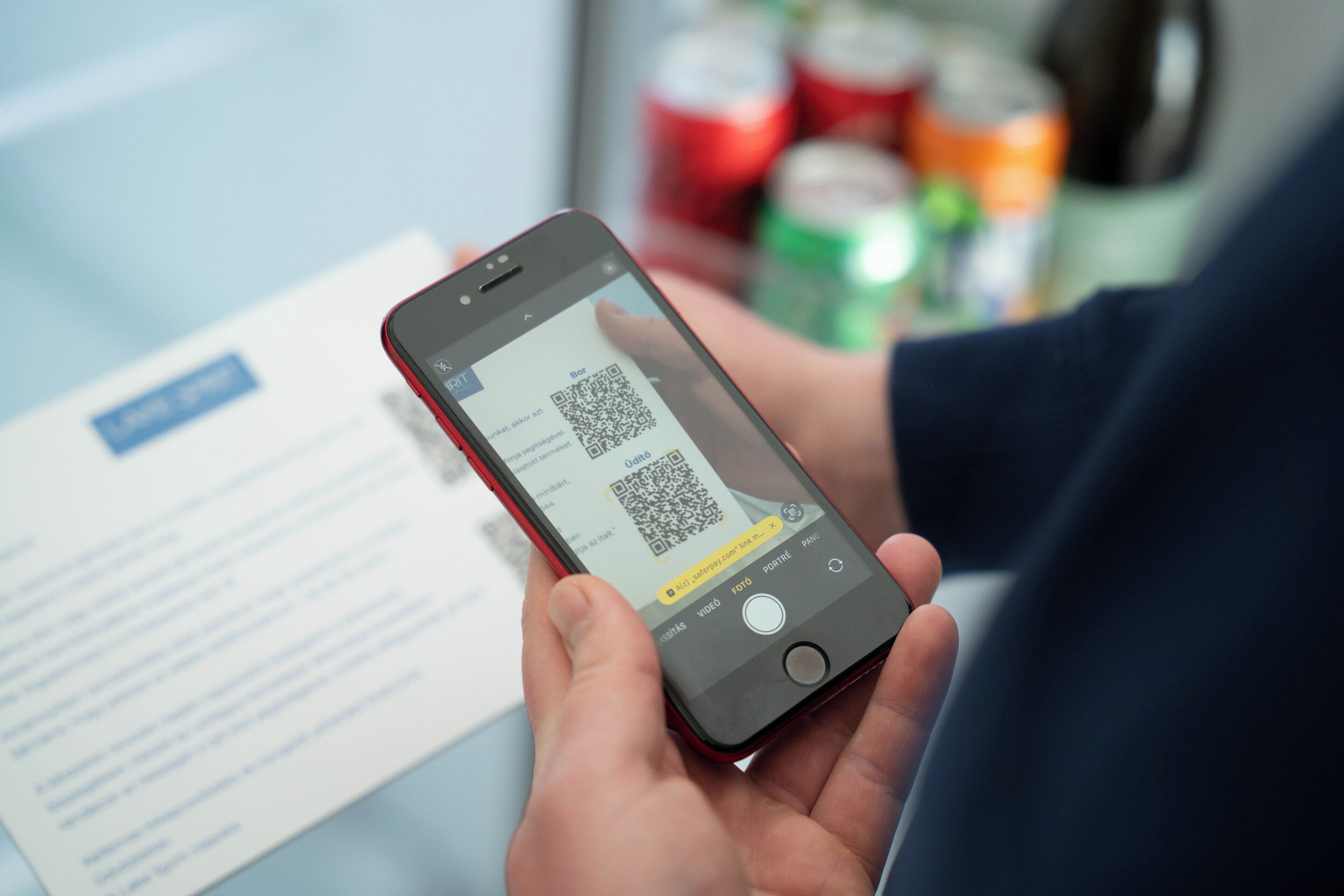 Una persona sosteniendo un teléfono inteligente que muestra un código QR.