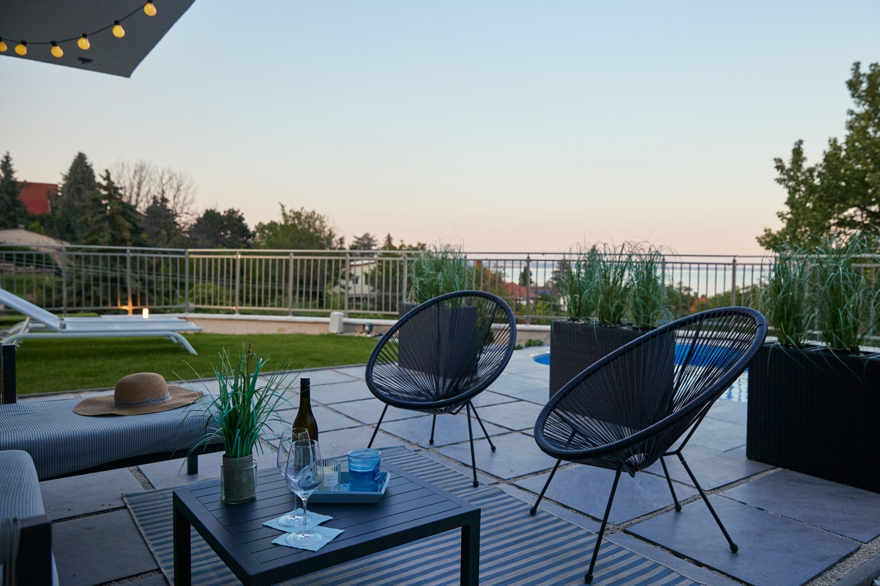An outdoor patio with a table, chairs, and a lounge area.