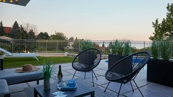 An outdoor patio with a table, chairs, and a lounge area.