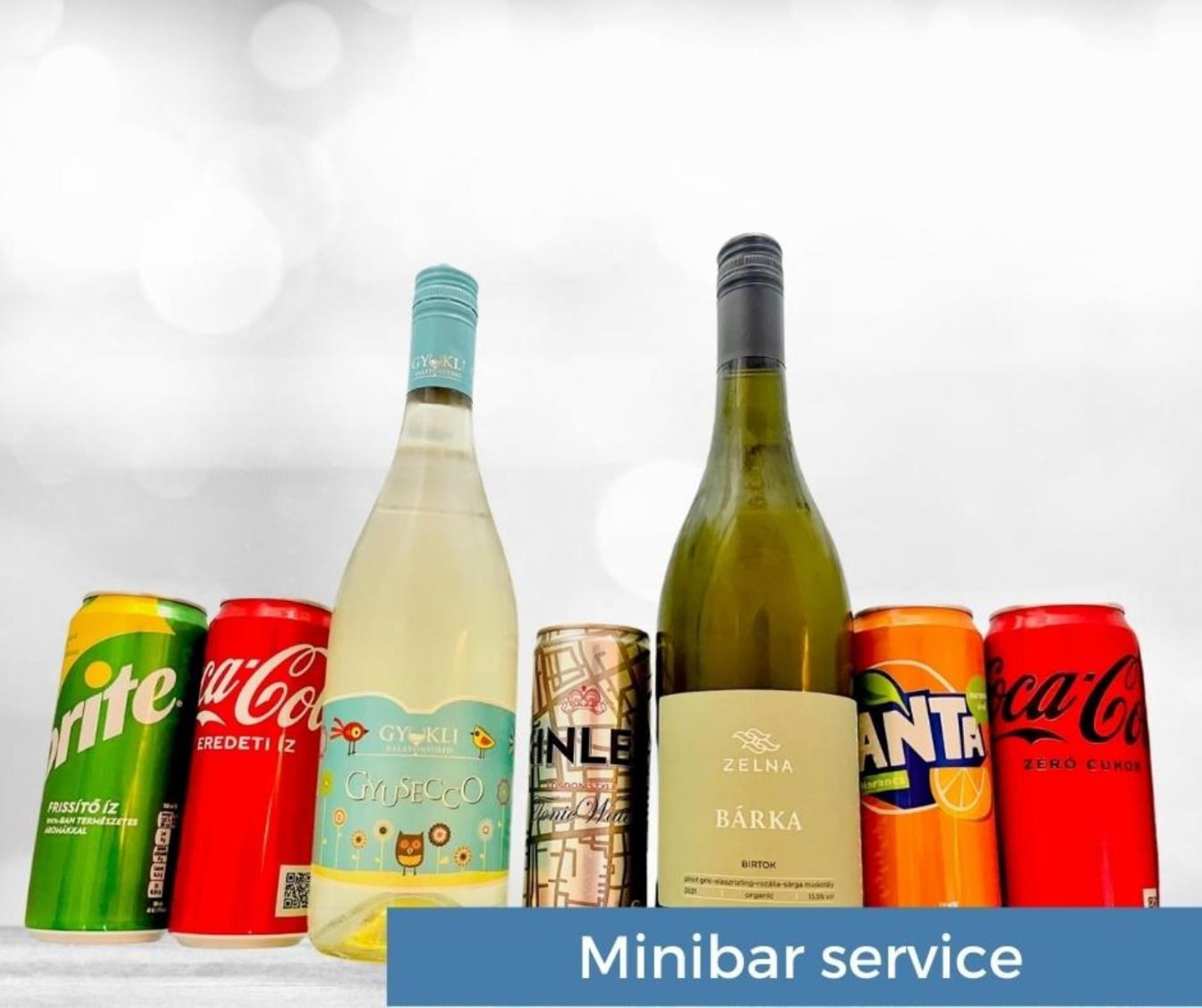 Diversas latas e garrafas de bebidas, incluindo Sprite, Coca-Cola, GYÖKLI, NILE, ZELNA BÄRKA e ANTANAS, com etiqueta indicando 'Serviço de minibar'.