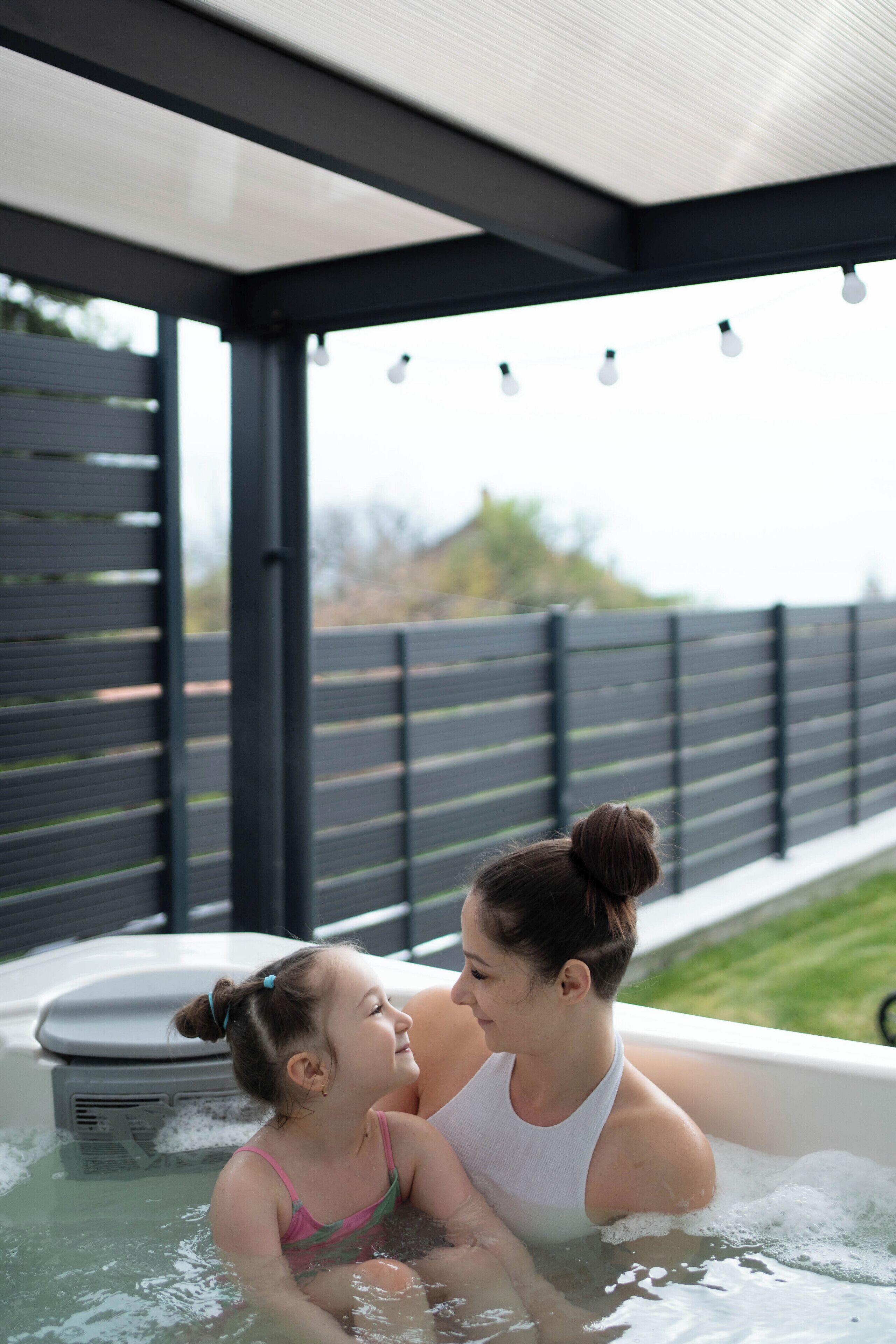 A hot tub with a wooden deck and a metal roof.