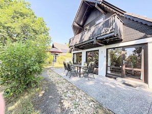 A building with a wooden balcony, a patio with chairs, and a number '38' on the wall. - Nice apartment in villa for 4 people with WIFI, TV and pets allowed (Bad Wildungen)