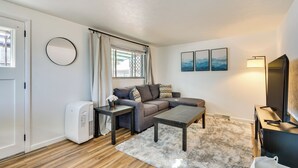 Ein gemütliches Wohnzimmer mit Sofa, Couchtisch, Fernseher und Heizung.