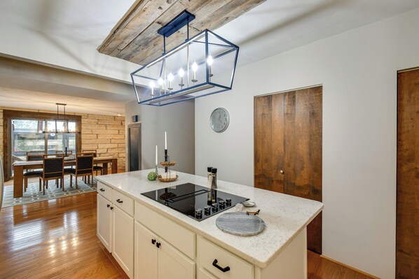 Una cocina moderna con una isla central, suelo de madera y techo rústico.