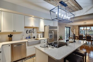 A modern kitchen with white cabinets, stainless steel appliances, and a central island. - Large Home w/ Game Room, 4 Mi to Mississippi River (Bettendorf)