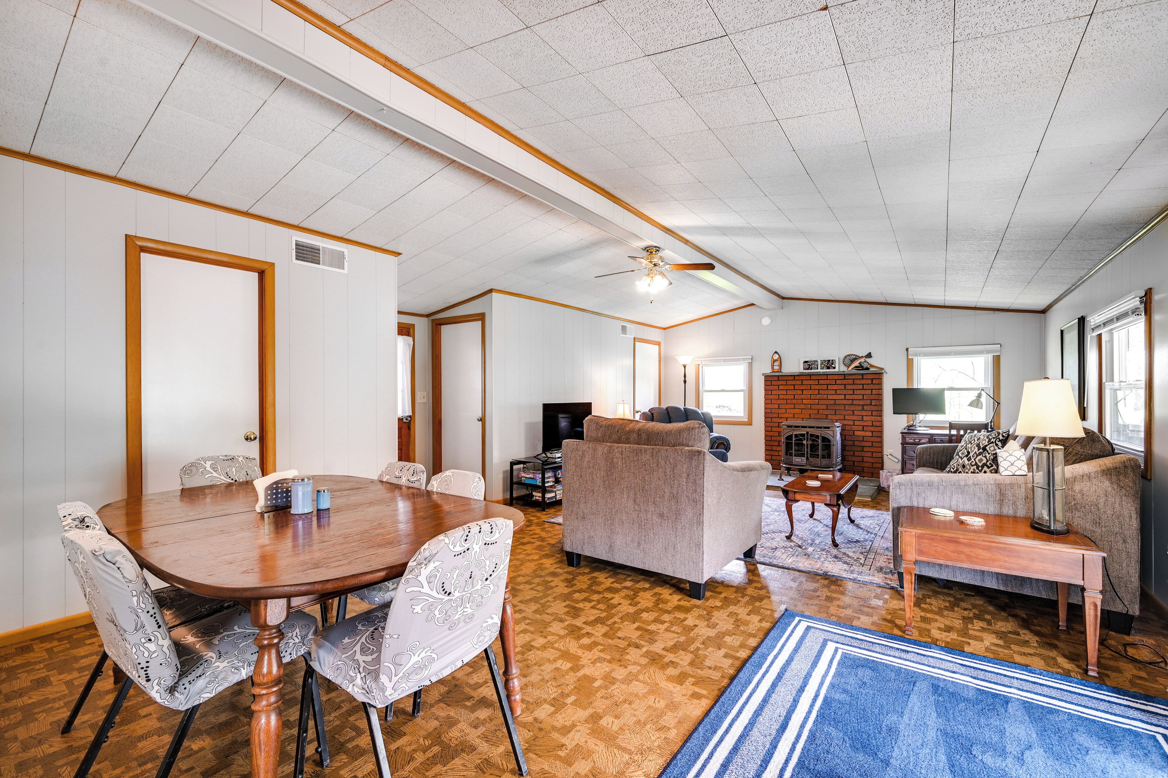 A spacious living room with a wooden dining table, two sofas, and a fireplace.