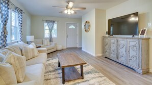 A living room with a sofa, coffee table, and a TV on a cabinet. - Ample Trailer/rv Parking! Family Home in Gulfport (Gulfport)