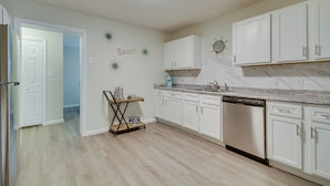 A kitchen with white cabinets, a dishwasher, and a coffee station. - Ample Trailer/rv Parking! Family Home in Gulfport (Gulfport)