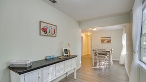 A modern kitchen with white cabinetry, a dark countertop, and a dining area with a white table and chairs. - Ample Trailer/rv Parking! Family Home in Gulfport (Gulfport)