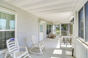 A covered porch with white rocking chairs and a wooden bench. - Waveland Vacation Rental - Walk to the Beach! (Waveland)