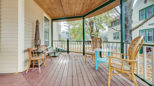 A wooden deck with wicker chairs and a table, overlooking a residential area. - Eau Claire Retreat: Close to Campus & Dtwn! (Eau Claire)
