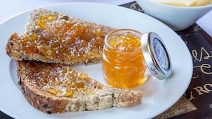 A plate with two slices of toast topped with honey, a jar of honey, and a bowl of butter. - Maxwelston Farmhouse (Girvan)