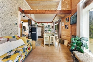 A cozy living room with a sofa, a dining area, and a kitchen.