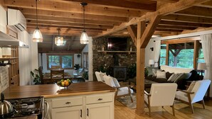 A rustic cabin interior with a kitchen, dining area, and living room. - Red Stone Retreat-10 Min to Asheville, Game Room, Firepit, Quiet and Secluded  (Swannanoa)