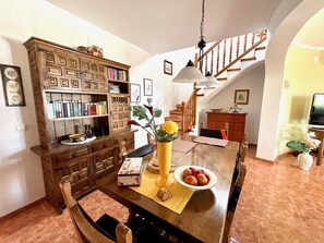 Enjoy meals in this cozy dining area with a table for two, bookshelf, and TV.
