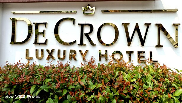 Un senyal per a De Crown Luxury Hotel, amb un símbol de corona sobre el nom.
