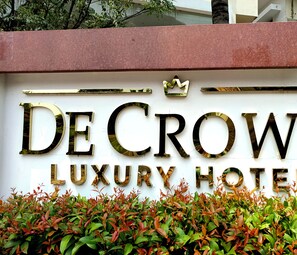A sign for De Crown Luxury Hotel with a crown symbol above the name. - DE CROWN LUXURY HOTEL (Kakinada)