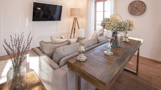 A modern living room with a sofa, a wooden coffee table, a TV mounted on the wall, and a window with curtains. - MY STAY: Relaxation between Chiemsee beach & Kampenwand, plenty of space with 79 sqm (Bernau am Chiemsee)