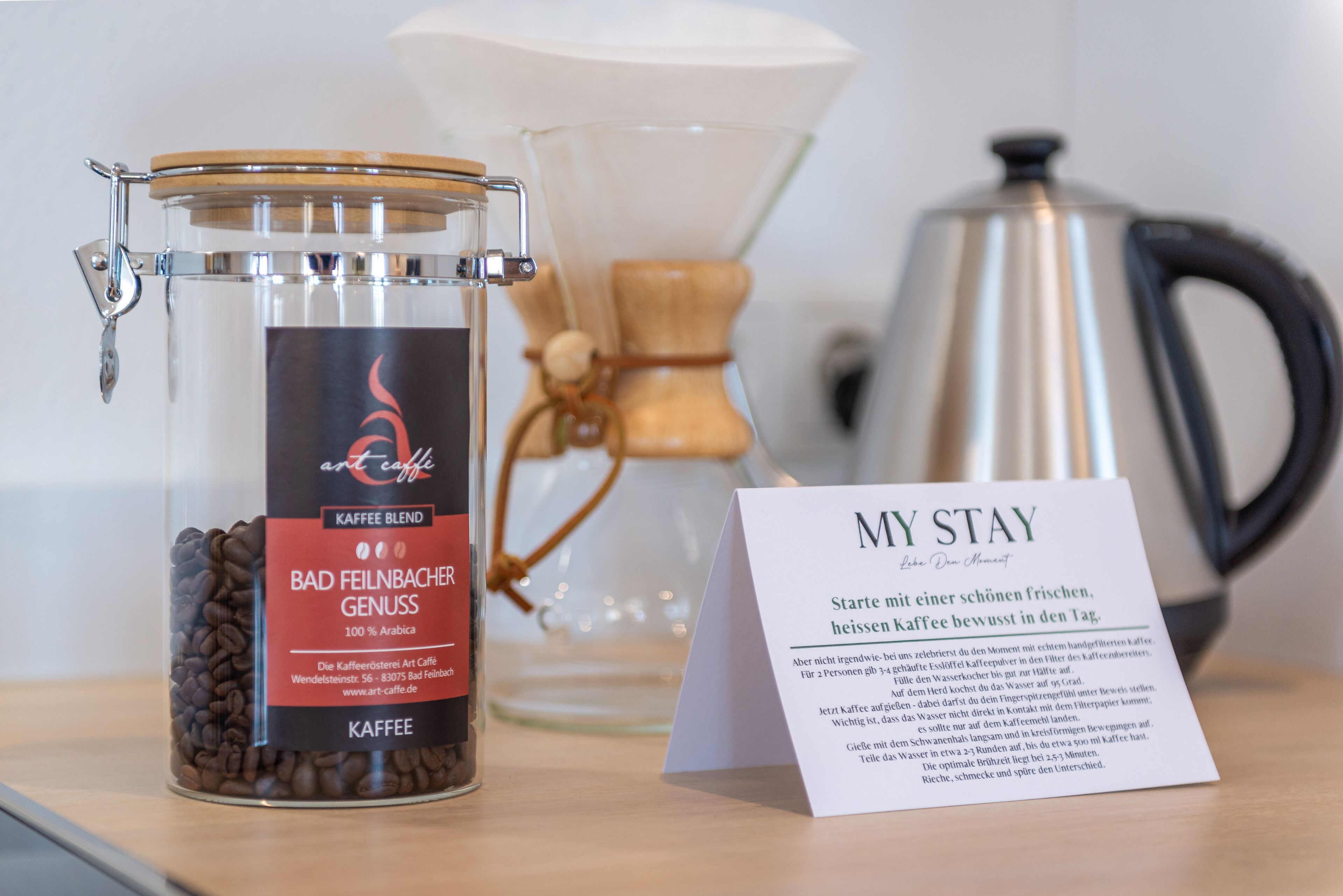 Un bocal de grains de café, un moulin à café et une pancarte portant l’inscription « MON SÉJOUR ».