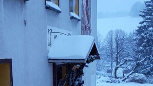 En bygning med en indgang dækket af sne og en gul dør.