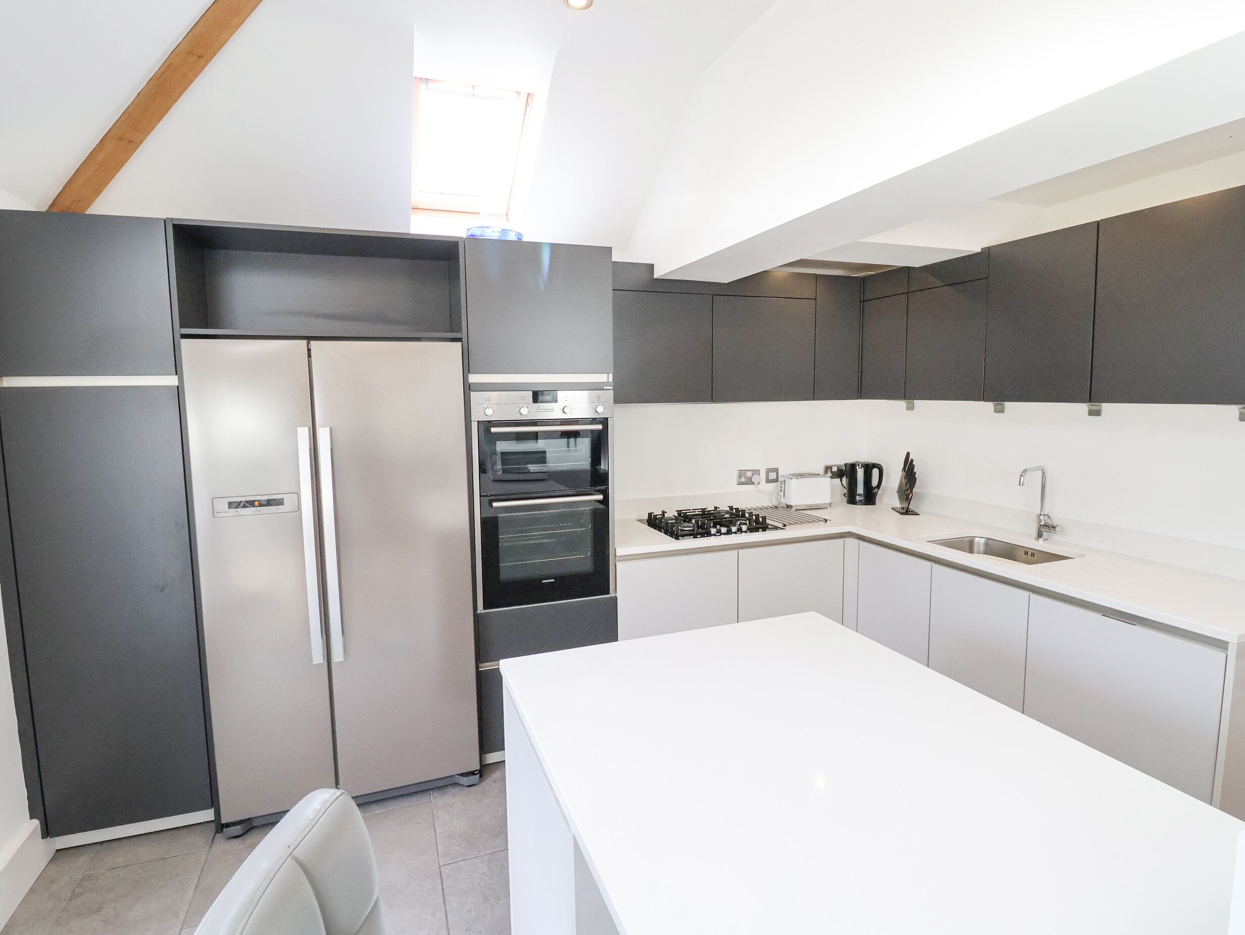 A modern kitchen with a built-in refrigerator, oven, and microwave.