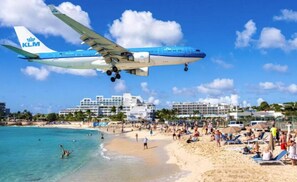 A beach with a KLM airplane landing. - Residence Alamanda (Orient Bay)