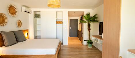 A modern bedroom with a wooden bed, a large window, and a built-in wardrobe.