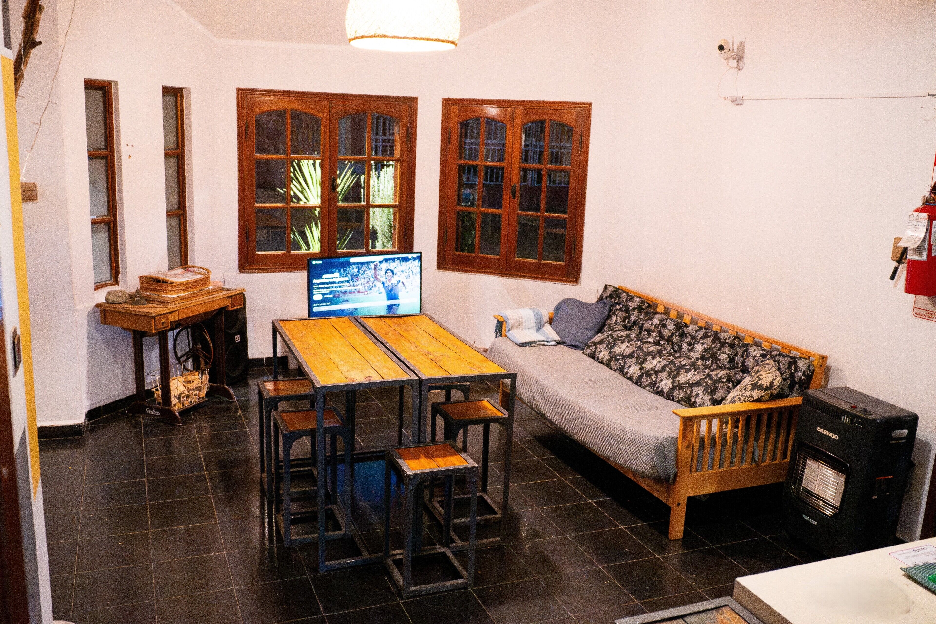 A cozy living area with a wooden table, a sofa, and a television.