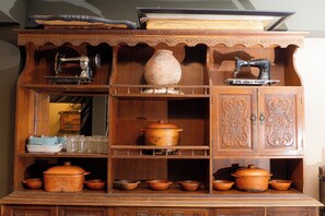 A wooden cabinet with various kitchen items including a sewing machine, pottery, and cookware. - HOSTEL La Casa de Li  En (Chilecito)